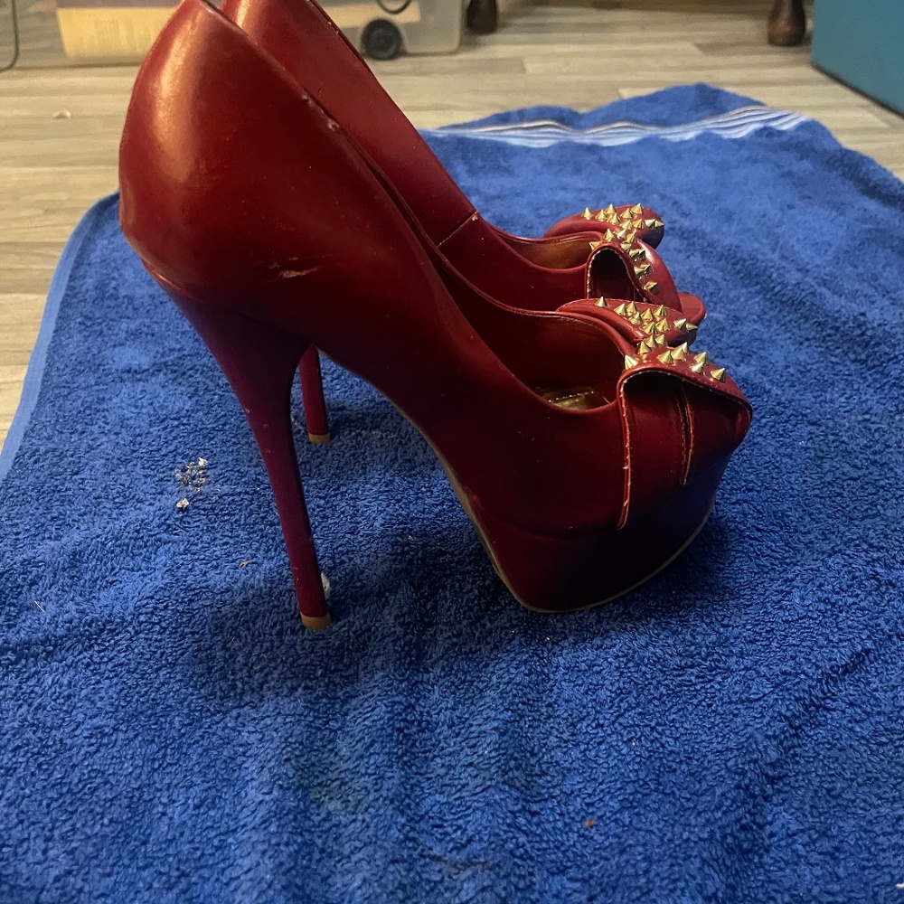 Cherry red stiletto heels with a bow and gold accents